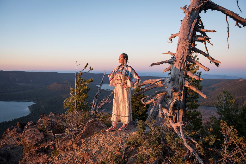 Native woman Acosia M. Red Elk in historic buckskin dress on top of Paulina Peak, Central Oregon, USA